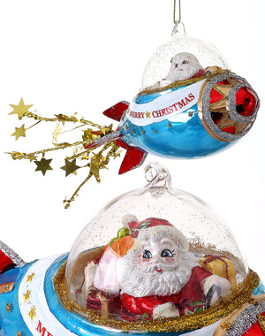 The Canton Christmas Shop 9 inch Glass Santa in Rocket ship Ornament Glittered with Stars and Merry Christmas on ship