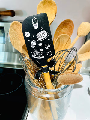 The Canton Christmas Shop Baking Is Love Made Edible Black Silicone Spatula with Wood Handle and Gift Bow Ribbon with Hanging Loop Reverse View with Cakes Cookies Cupcakes