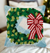 The Canton Christmas Shop Festive Wreath with red and white striped bow and blue gingham background hooked throw pillow