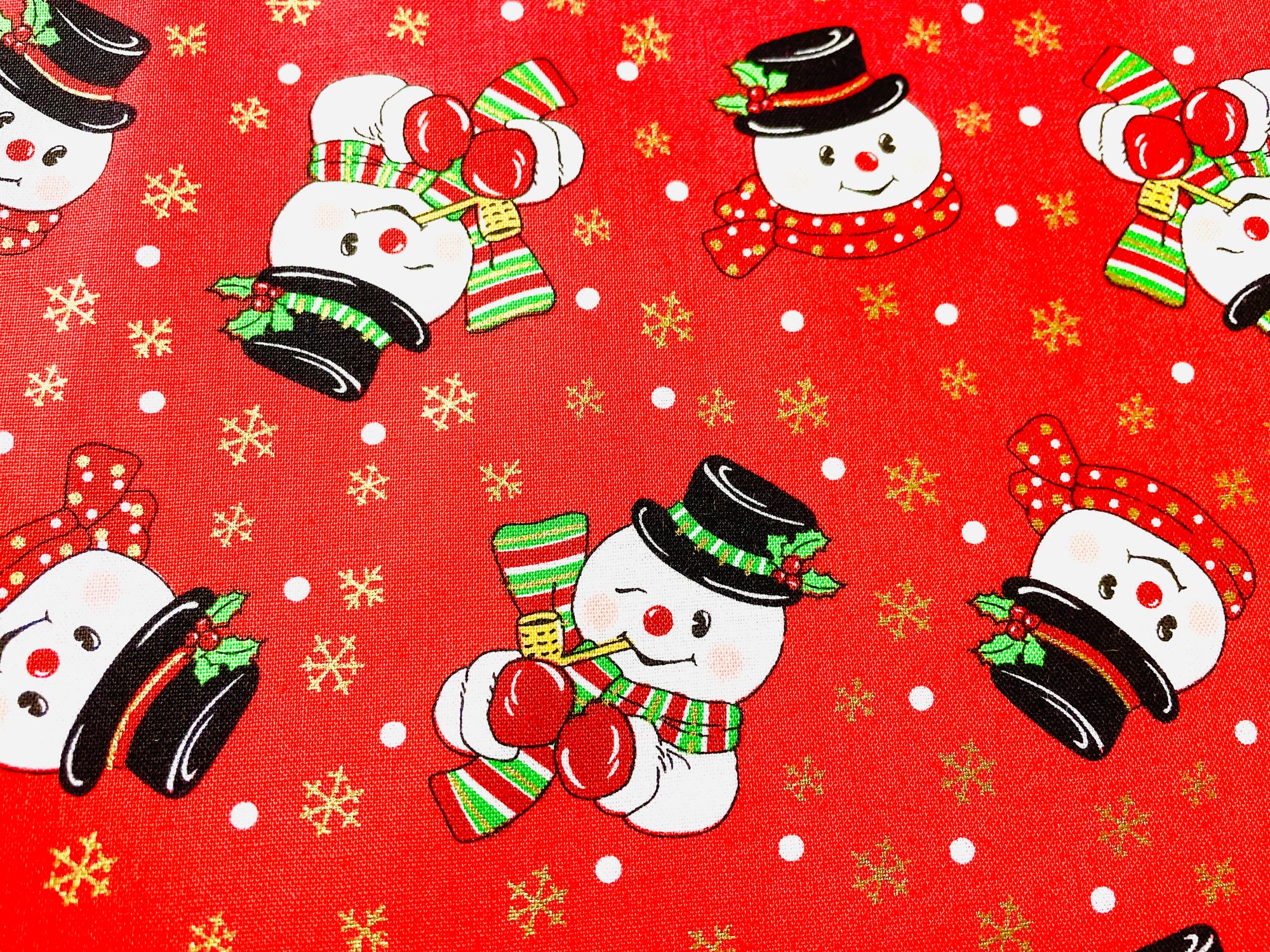 The Canton Christmas Shop Frost the Snowman Christmas Baking Cooking Apron Red Background Gold Snowflakes Corn Cob Pipe Button Nose Two Eyes Made Out of Coal by Two Medium Sized Ladies fabric pattern