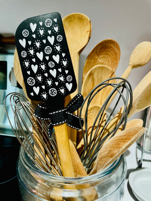 The Canton Christmas Shop Grandmas Never Run Out of Kisses or Cookies Black Silicone Baking Spatula Ready for Gifting with Black Ribbon Bow and Hanging Loop reverse side with hearts