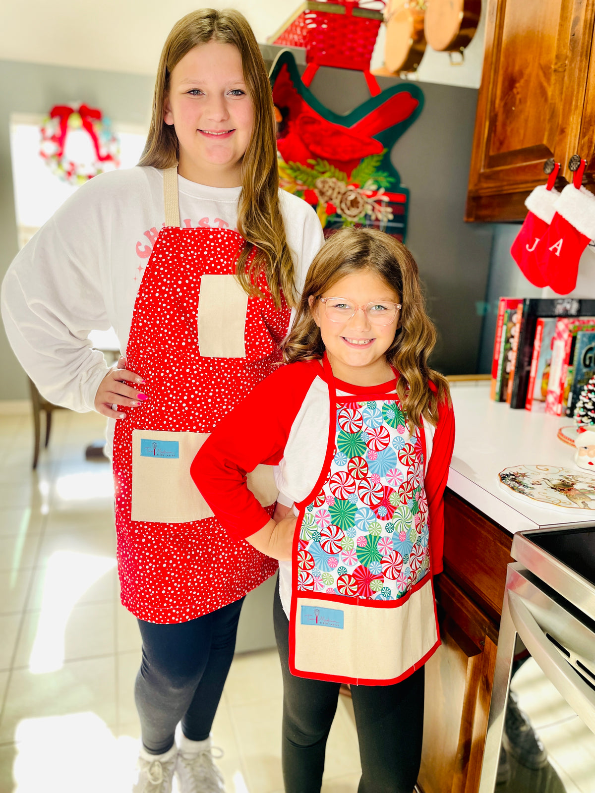 The Canton Christmas Shop Vintage Snowfall Apron and children&#39;s Peppermint Lane apron by Two Medium Sized Ladies handmade in Texas