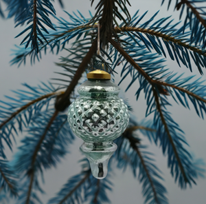 The Canton Christmas Shop Aqua Glass Finial Ornament hanging from green tree branch