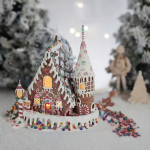 The Canton Christmas Shop 13" Pre-Lit Claydough Gingerbread Inn with C7 Bulb on tabletop in snowy village scene