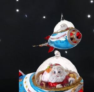 The Canton Christmas Shop 9 inch Glass Santa in Rocket ship Ornament Glittered with Stars and Merry Christmas on ship